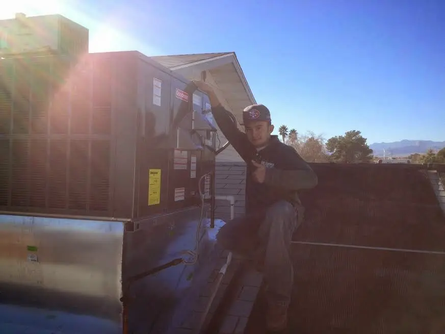 HVAC technician performing AC Tune-Up on a rooftop unit in Anna
